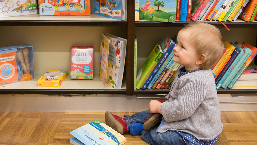 Child checking out Cradle to Cradle certified books in a bookshop